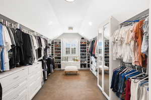 Spacious closet with carpet floors and lofted ceiling