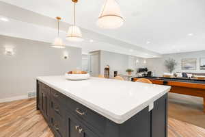 Kitchen featuring hanging light fixtures, light hardwood / wood-style floors, and a kitchen island