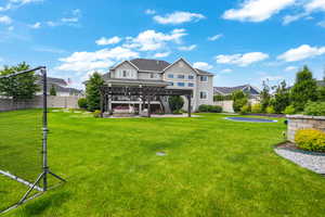 Back of property featuring a patio area, a pergola, and a yard