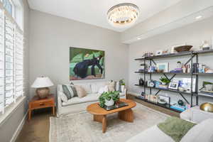 Carpeted living room featuring a notable chandelier