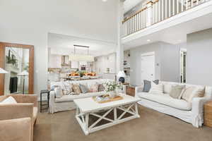 Carpeted living room with a towering ceiling