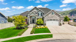 View of front facade with a garage, a front yard, and a mountain view