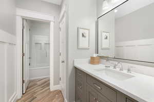 Bathroom featuring wood-type flooring, vanity, and tiled shower / bath combo