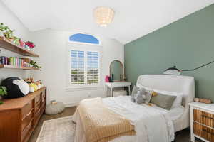 Bedroom featuring dark carpet and lofted ceiling