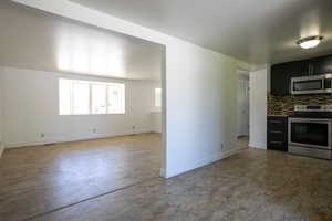 Kitchen with tile floors, stainless steel appliances, and tasteful backsplash