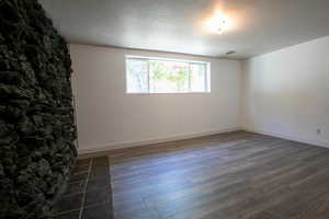 Spare room featuring dark hardwood / wood-style floors and a textured ceiling