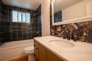 Full bathroom featuring vanity, toilet, and tiled shower / bath combo