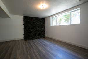 Interior space with a textured ceiling and dark hardwood / wood-style flooring