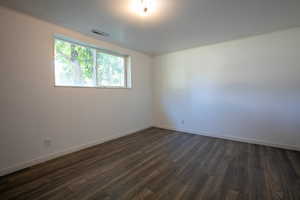 Unfurnished room with dark hardwood / wood-style floors