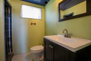 Bathroom featuring tile floors, vanity, and toilet