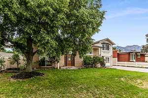 View of front of home with a front lawn and a mountain view