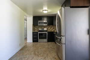 Kitchen featuring stainless steel appliances and backsplash