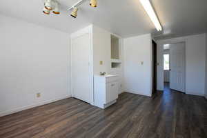 Washroom with sink, track lighting, and dark hardwood / wood-style flooring