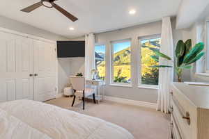 Bedroom with light colored carpet, a closet, and ceiling fan