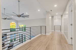 Hall with light hardwood / wood-style floors and lofted ceiling