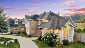 View of front of house featuring a yard, a mountain view, and solar panels