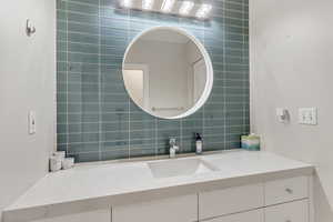 Bathroom with tile walls, backsplash, and large vanity