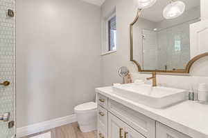 Bathroom with wood-type flooring, toilet, and vanity with extensive cabinet space