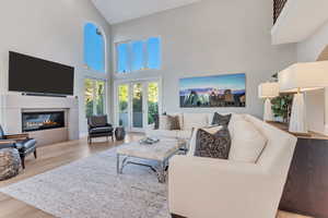 Living room featuring light hardwood / wood-style floors and a towering ceiling