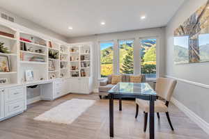 Home office featuring built in desk and light hardwood / wood-style flooring