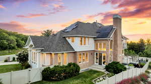 View of front of property with a yard, a balcony, and solar panels