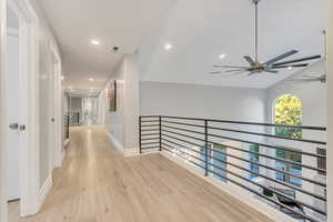 Corridor featuring lofted ceiling and light wood-type flooring