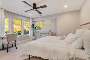 Bedroom featuring ceiling fan, multiple windows, and light colored carpet