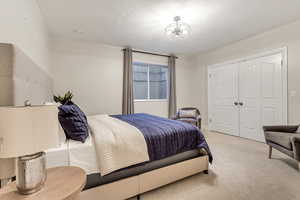 Carpeted bedroom featuring a chandelier and a closet