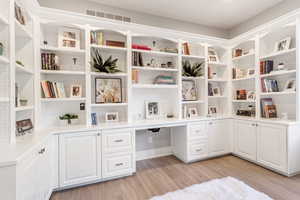 Office area featuring built in desk and light wood-type flooring