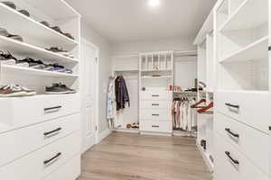 Walk in closet featuring light wood-type flooring