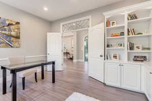 Office space with built in features and light wood-type flooring