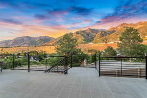 Patio terrace at dusk with a mountain view and a balcony