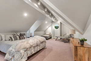 Carpeted bedroom with vaulted ceiling and track lighting