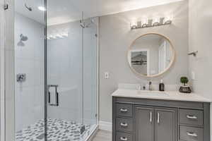 Bathroom with walk in shower, wood-type flooring, and large vanity