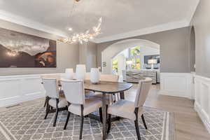 Dining room with light hardwood / wood-style floors, ornamental molding, and a chandelier