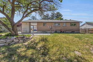 Rear view of house featuring a yard and a patio area