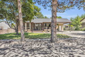 View of front of house featuring mature trees provides a shaded, private front lawn.