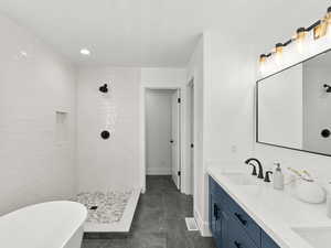 Bathroom with a tile shower, tile flooring, double sink, and vanity with extensive cabinet space