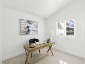 Office space with carpet flooring and vaulted ceiling