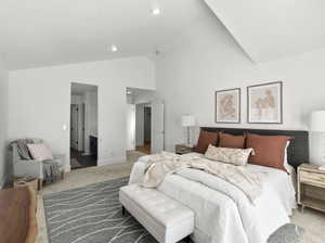 Bedroom with high vaulted ceiling and carpet flooring