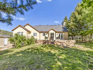 Back of house with a patio area, a yard, and an outdoor structure