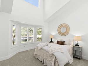 Bedroom with a towering ceiling and carpet flooring