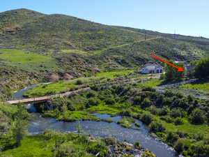 Birds eye view of property with a water and mountain view