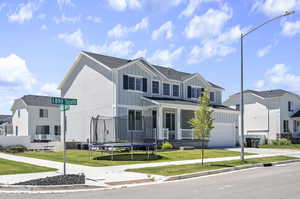 View of front facade with a garage, a trampoline, and a front lawn