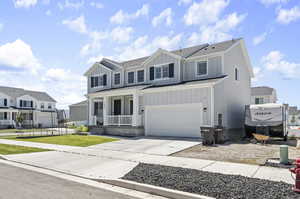 View of front facade featuring a garage and a front lawn