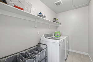 Laundry room featuring separate washer and dryer and light tile flooring