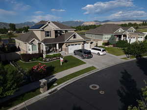 Craftsman-style house featuring a front yard, a garage, a mountain view, and solar panels