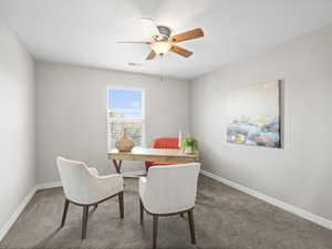 Carpeted dining area with ceiling fan