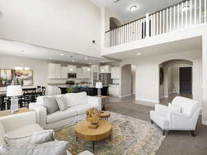 Carpeted living room with a high ceiling