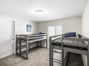 Carpeted bedroom with a textured ceiling